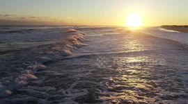 Bird's eye view of surf over New York coast at sunrise