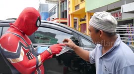 A MAN DRESSED SPIDERMAN COSTUME FOR DISTRIBUTE MASKS