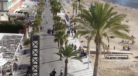 Timelapse of people walking along a promenade in Benidorm, Spain from above, pre Covid