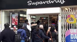 Customers queue outside London Superdrug for hand santiser