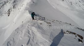 Skialpinist nearly fell down form the steep ridge.