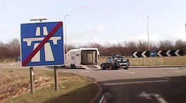 Moment race car rolls out of trailer onto busy UK highway