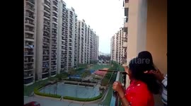 People in India come out onto their balconies to clap and ring bells to support health workers