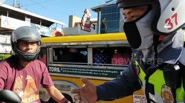 Philippine police stop and confiscate licenses from motorcyclists who are not wearing face masks
