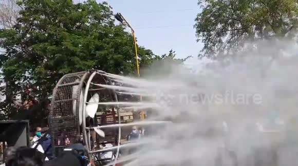 Indian officials use high-pressure water jets attached to fan to spray disinfectant