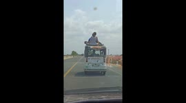 Two reckless tourists ride on taxi roof in Cambodia