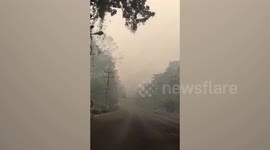 Drivers battle through thick clouds of smoke from forest fires in northern Thailand
