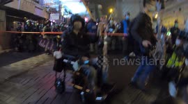 Man in wheelchair brings a white flower (symbol of mourning) before police cordon in front of Prince Edward station