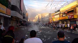 People protesting in the streets, some of them steal things from the super market
