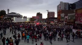 People turning on the light of their cell phones after the march in the main square of the city