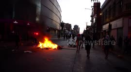 Hooded man exercises on a mini mat in front of special forces, amid protests in Chile