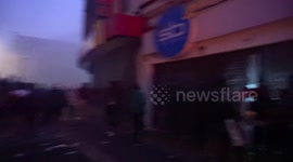 Hooded people in the city center after the protests, some commercial premises destroyed and others burned down