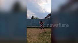 Boy plays badminton over garden fence during lockdown