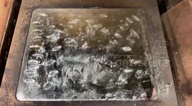 Skimming a vat of solder.