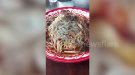 Live crabs try to escape from spicy Thai papaya salad before being eaten