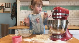 Cute three-year-old uses standing mixer for the first time