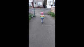 2 year old toddler running from parent  on a overcast day