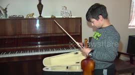 10 year old boy in isolation and learning to play the violin himself