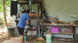 Large snake caught sheltering from  the rain in Thai family's kitchen pots and pans