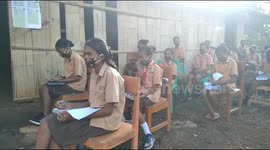Eastern Indonesian school students listen to the radio in their schoolyard during the covid-19 pandemic