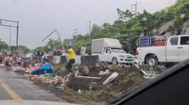 Hungry Thai locals scavenge two tons of sausages spilled from overturned truck