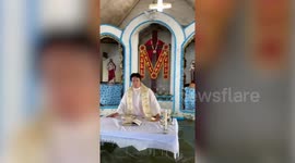 Filipino priest gives service in flooded church while parishioners attend in boats