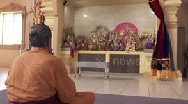 Man Praying In Front of Deity Statues