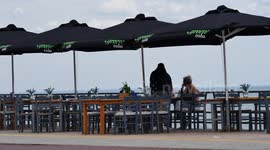 People enjoy drinks and meals in a cafe-bar in Alexandroupoli, Greece