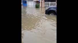 Vehicles seen driving through flooded streets after severe storm hits east Samarinda, Indonesia