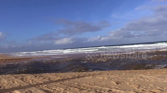 Heavy rain in New South Wales triggers massive release of water from lagoon into ocean