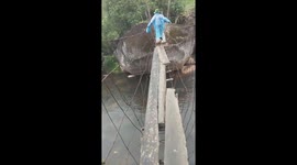 People risked their way across a damaged wooden bridge after the flood