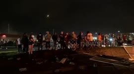 Demonstrators look on as fires burn at Minneapolis 3rd Police Precinct