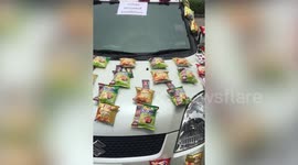 Kind couple hand out snacks stuck to their 'community pantry' car during COVID-19 pandemic