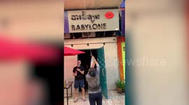 Cambodian residents use long rope to deliver food to balcony