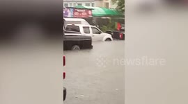 Vehicles trapped on Thai road submerged by deep floodwater