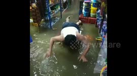 Man swims on flooded floor at shop in Sulawesi Indonesia