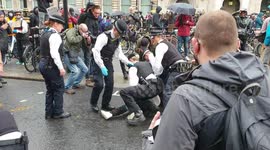 Police on Whitehall tackle an arrested man to the ground after he kicked out at a police officer