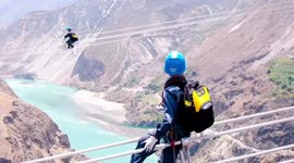 Chinese electricians conduct maintenance on power lines 400 metres above river