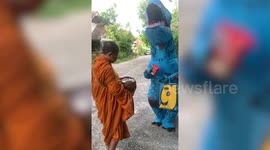 Dinosaur donates food to Buddhist monks