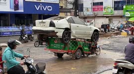 Overloaded motorcycle carries scrap car on the back in Cambodia