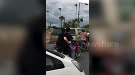 Hungry wild monkey leaps onto motorcycle to steal passenger's food