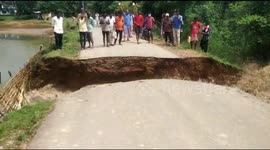 Villagers watch as road collapses into flooded river in northeastern India