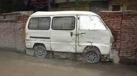 Abandoned minibus built into wall to fill the gap in China