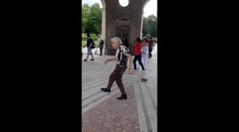 Cheerful and energetic grandpa shows off his dancing moves in a court garden