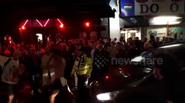 Guy twerks against car trying to navigate through Soho Super Saturday crowd