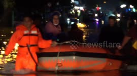 Indonesian pedestrians transported by rubber boats after persistent rain leaves Padang flooded