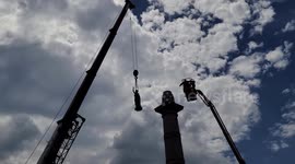 Construction crews lift statue from the Jefferson Davis Confederate Memorial on Monument Avenue in Richmond, Virginia