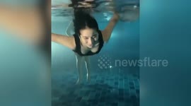 Spooky moment mystery 'ghost legs' are seen behind woman in swimming pool
