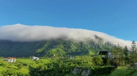 Breathtaking moment clouds flow over mountaintop in Thailand