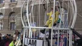 Bizarre! Dame Vivienne Westwood suspended 10 ft in the air inside giant bird cage in London
